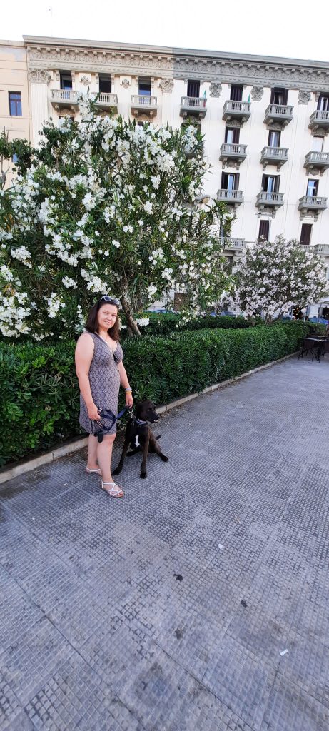 Blooming flowers and girl and a dog posing in Bari, Italy